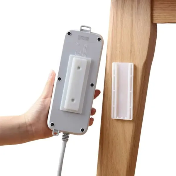 Selvklebende holder for strømuttak